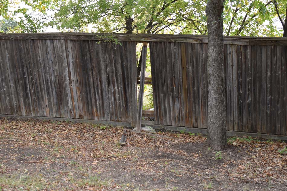 Image of a wooden fence missing pickets.