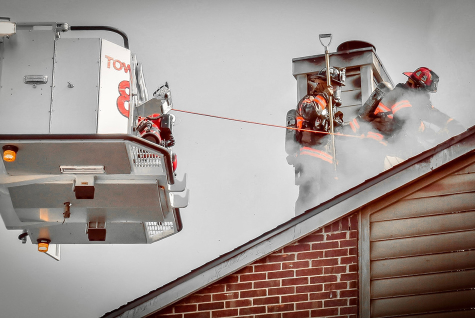 Two firefighters ventilating a roof