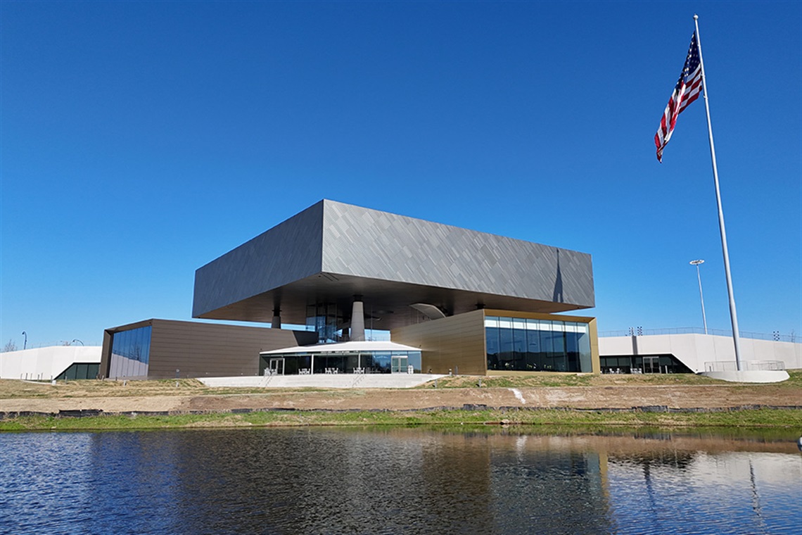 Image of the exterior of the National Medal of Honor Museum with a blue sky and an American flag. 