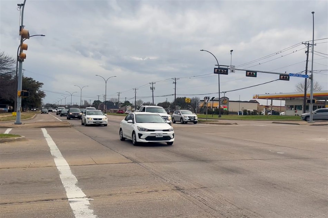 Intersection with NoTraffic Technology with multiple cars and visible traffic lights and road signs.