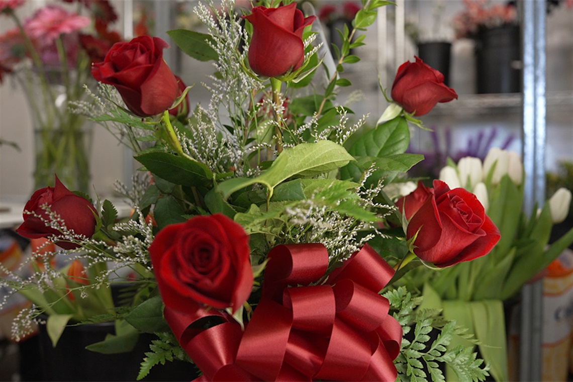 Roses on display in a refrigerated cooler.