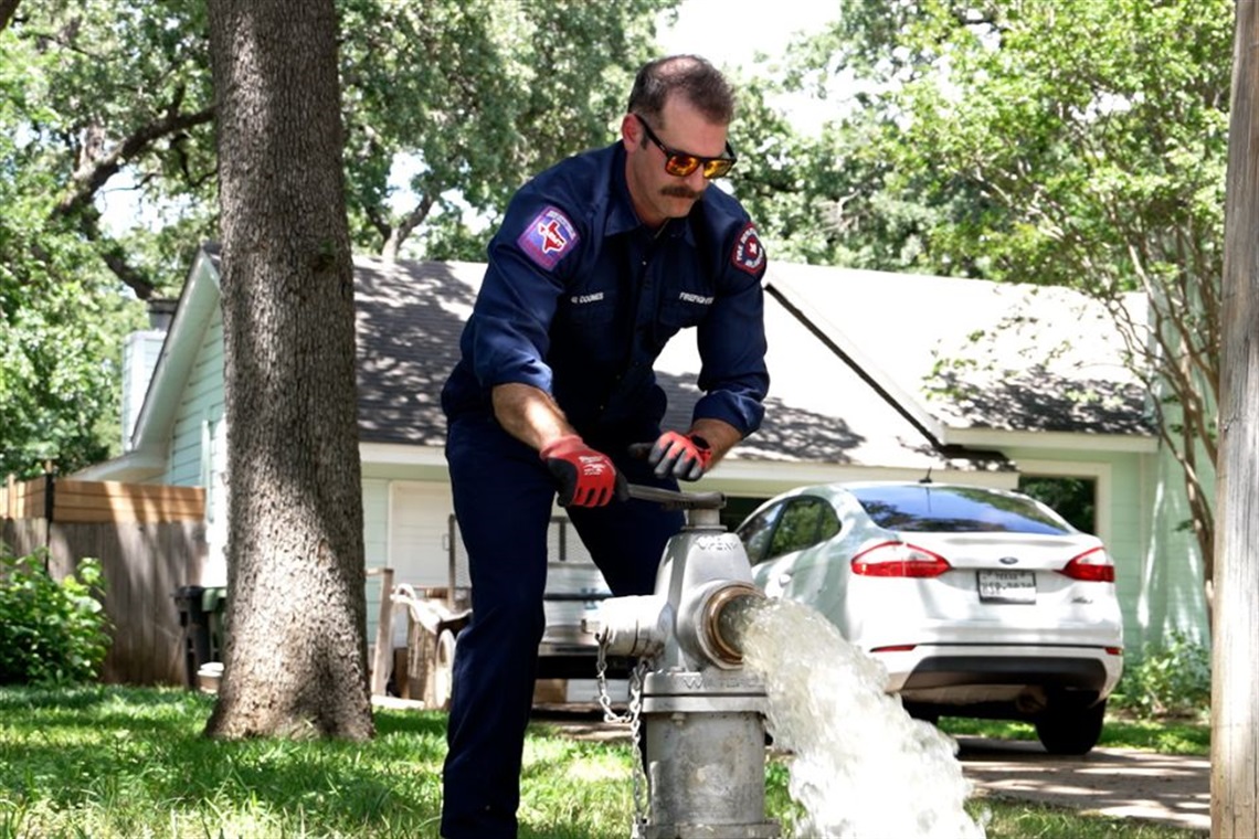 Arlington firefighter testing a fire hydrant in a neighborhood in 2025.