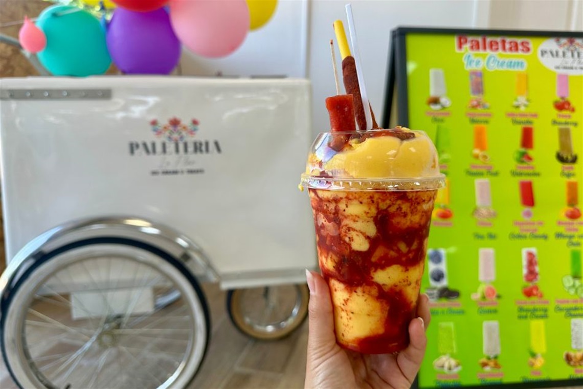 A colorful fruit dessert featuring layered yellow and red sauces.