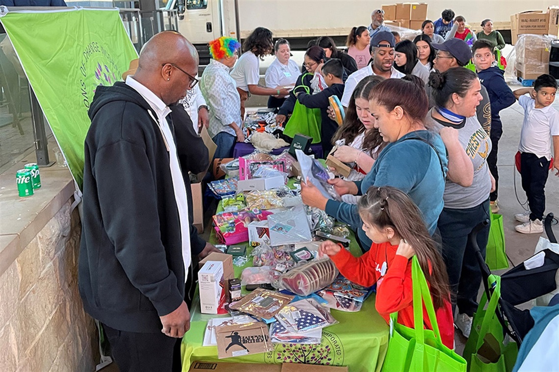 People standing at a booth receiving swag and resources People standing at a booth receiving swag and resources