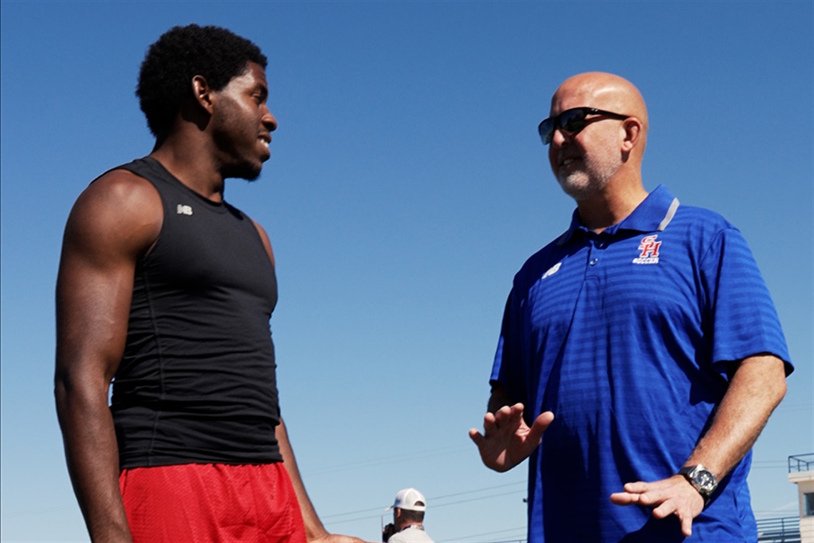 Jayden Scurlock speaks with Coach Chris James outside.