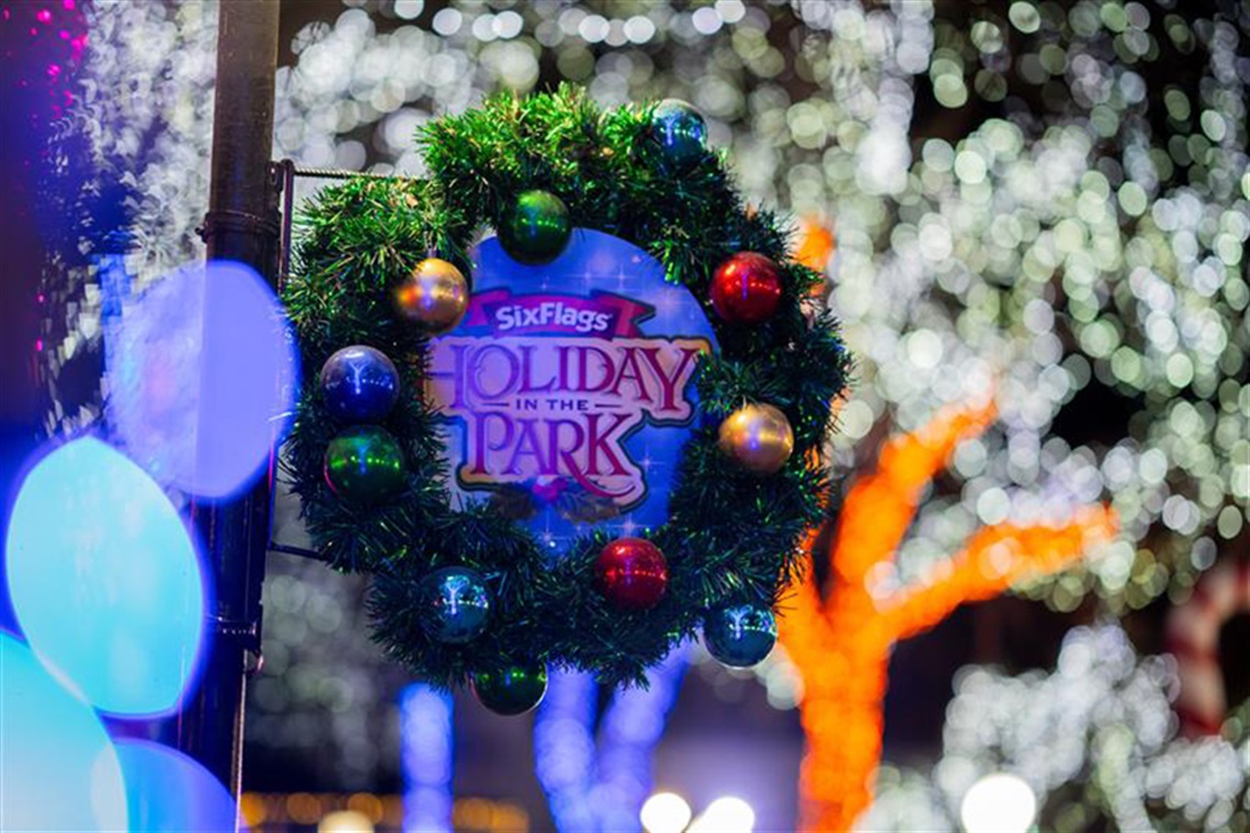 Wreath around a sign that says Six Flags Holiday in the Park