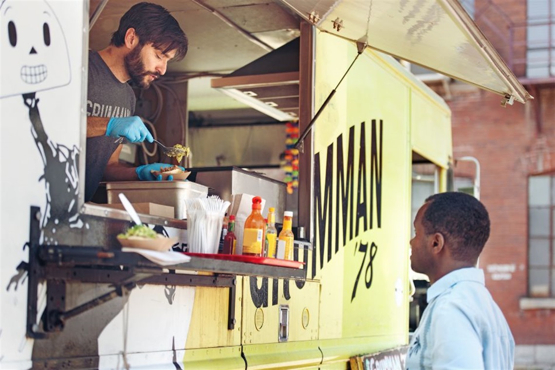 A person is being served food from a food truck.