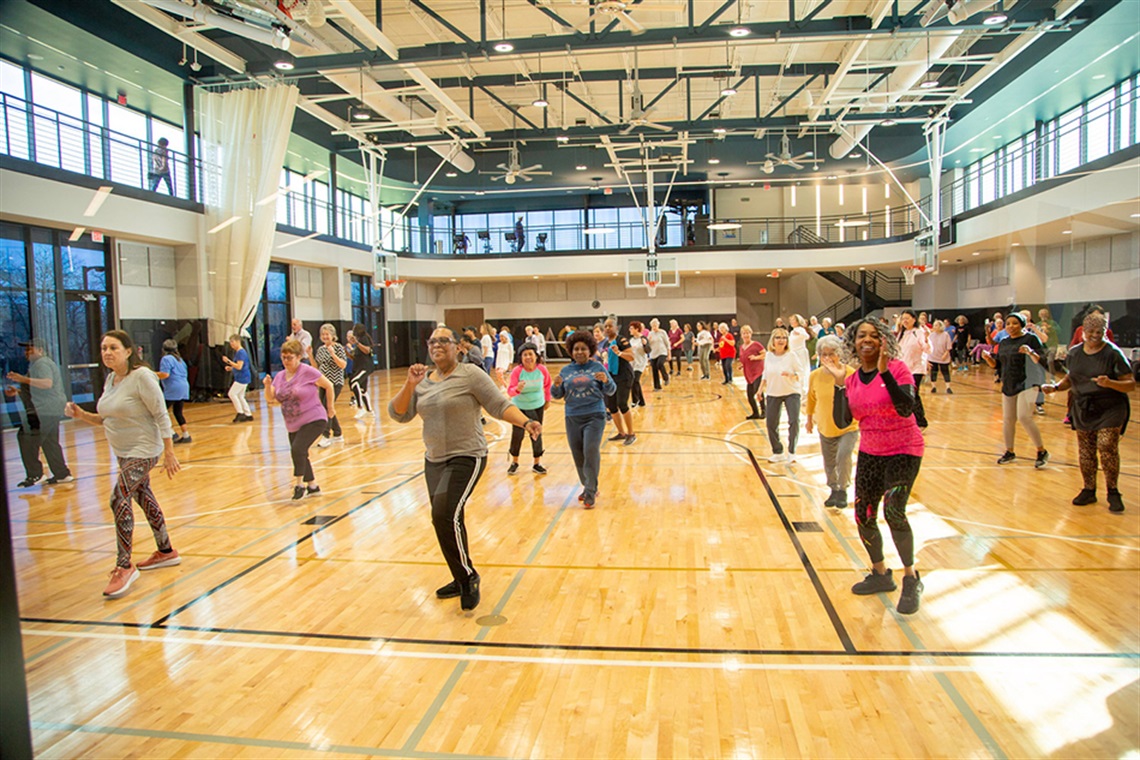 Ground of older adults doing an exercise class in a gym