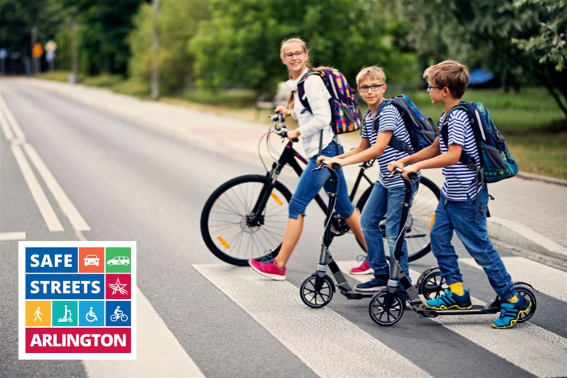 Children with a bicycle and scooters safety crossing the street at a crosswalk