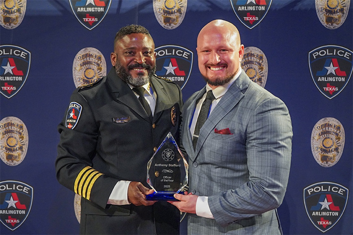 Chief Jones and Detective Stafford smiling and holding an award