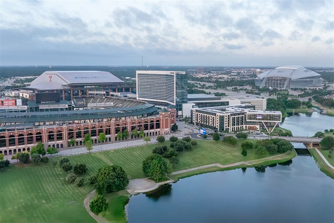 Arlington Entertainment District with green grass and a lake in the foreground