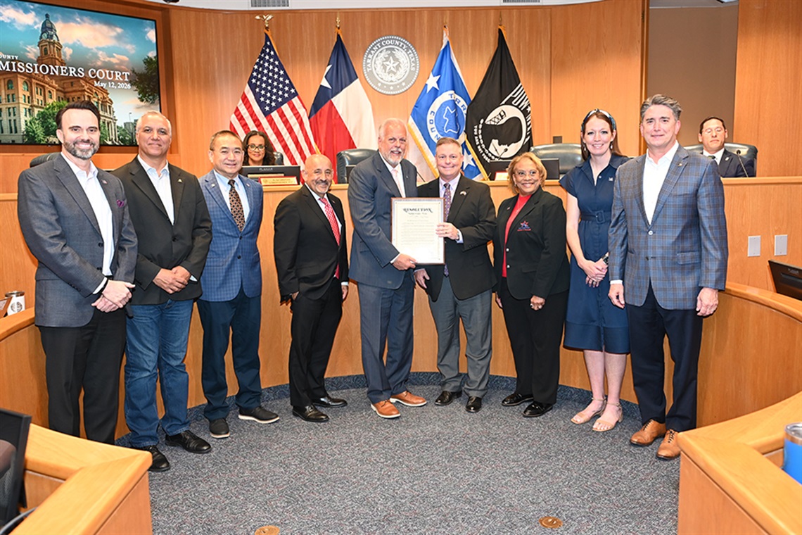 Arlington and Tarrant County dignitaries pose for photo with proclamation recognizing Arlington's sesquicentennial.