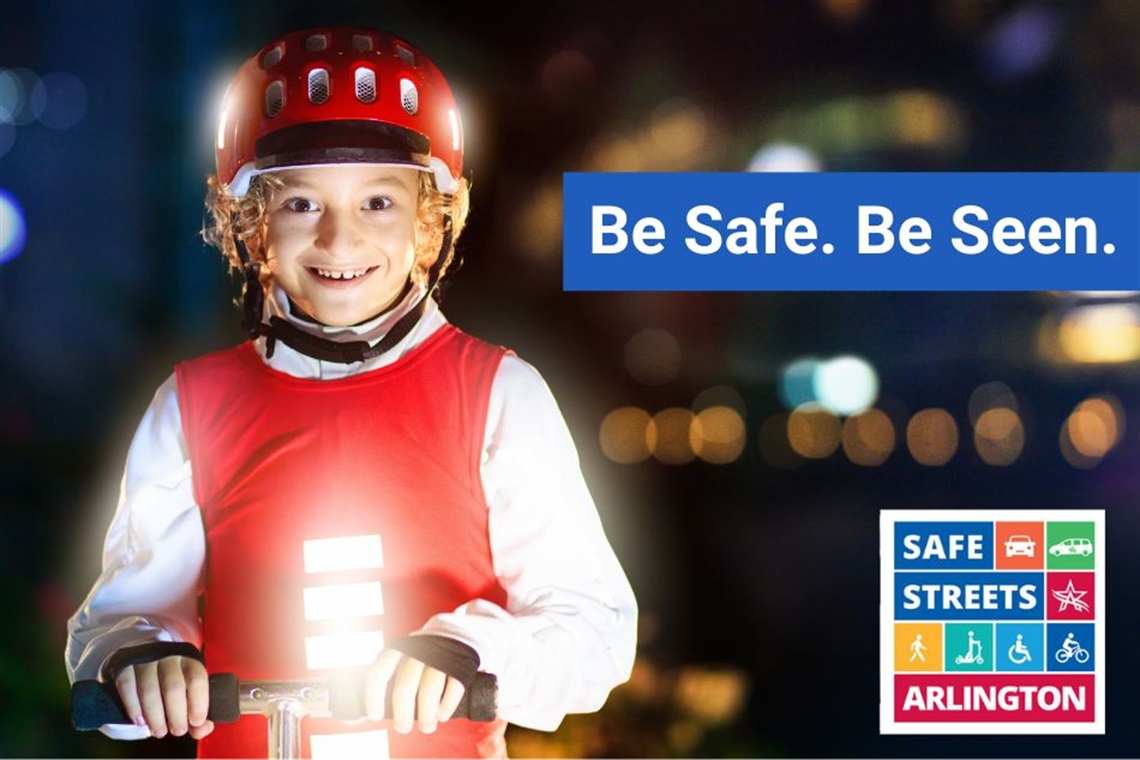 Child wearing a helmet and reflective vest while riding a bicycle at night.