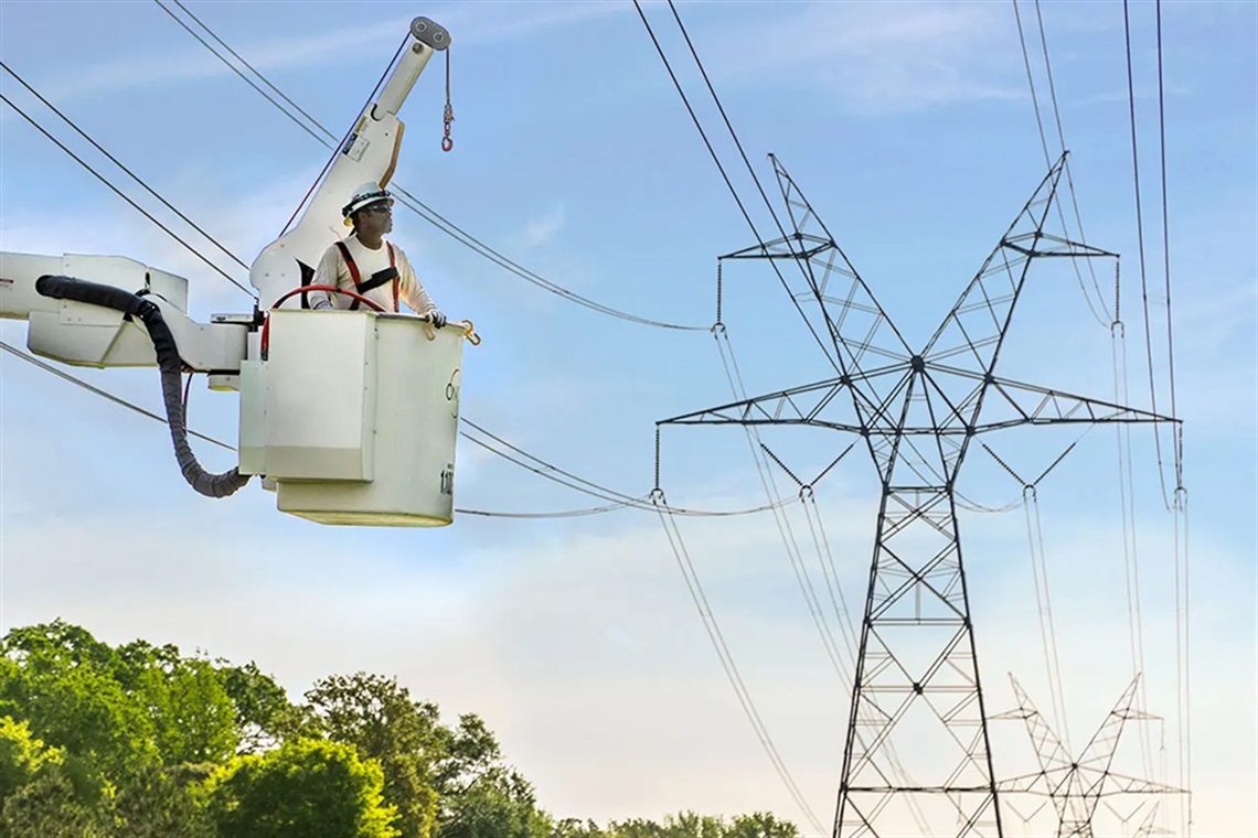 Oncor worker in a bucket truck working on transmission lines.