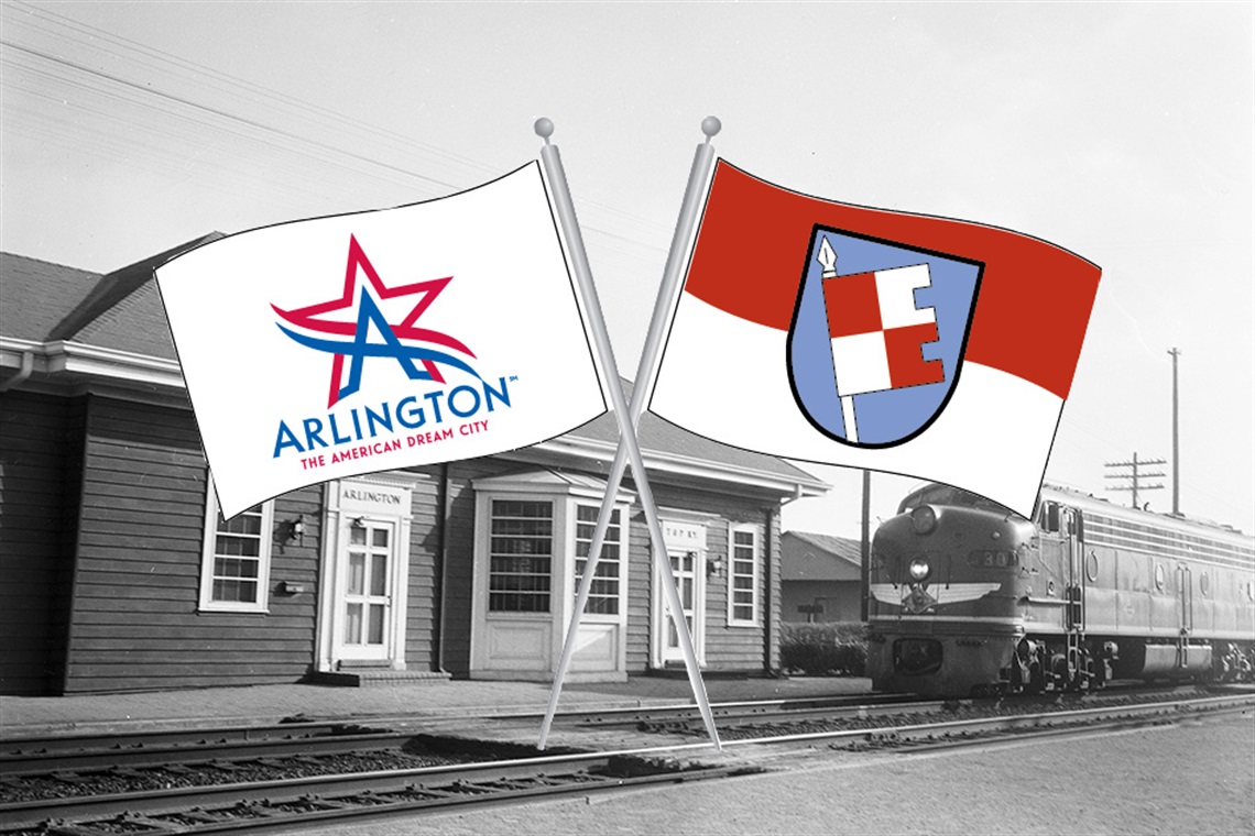 Historic train depot with city flags of Arlington and Bad Königshofen, Germany.