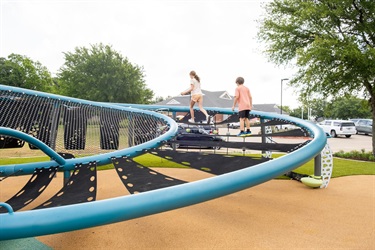 Kids climbing on play structure at Al Rollins Park