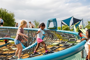 Kids playing on climbing structure at Al Rollins Park