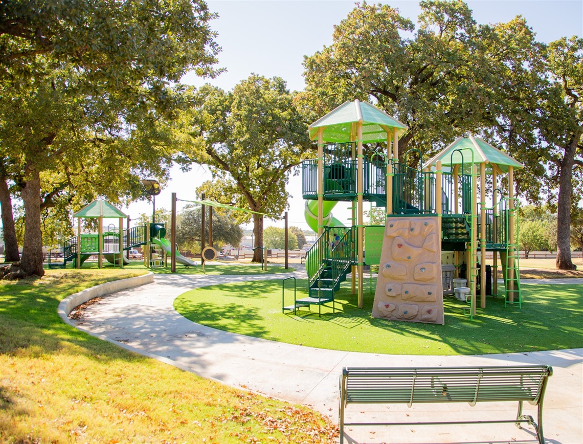 Playground, bench, and paved walking path at High Oak Park