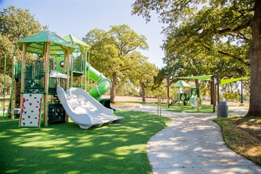 Paved walking path and small playground at High Oak Park