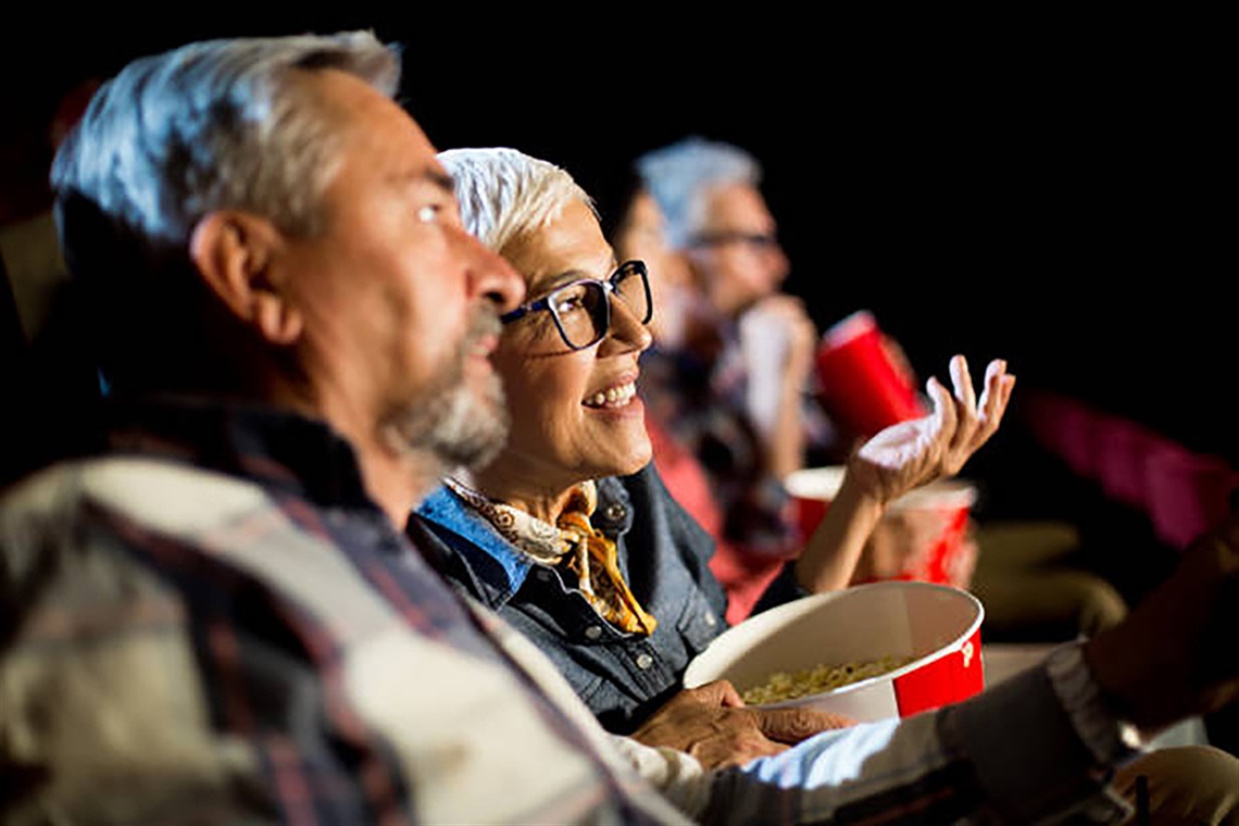 Seniors eating popcorn while watching a movie