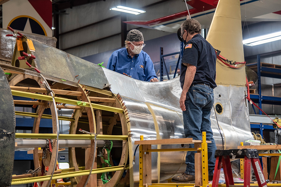 Two men looking at aircraft frame