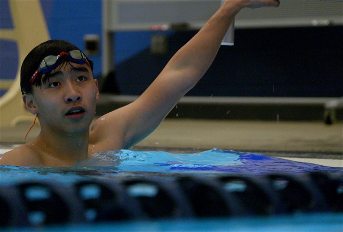 Paul Nguyen wades in a swimming pool.