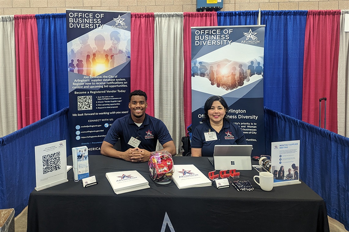 MBWE staff sitting at booth
