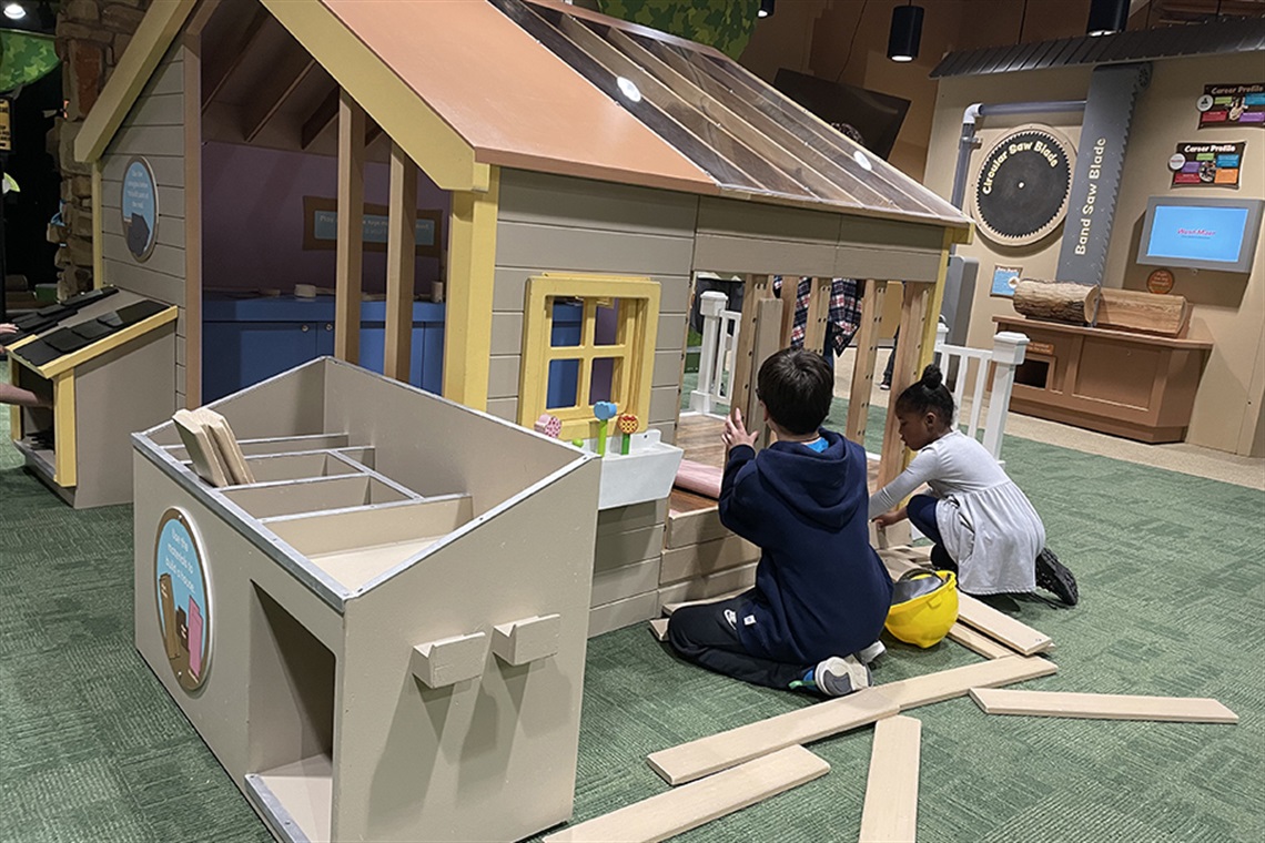 Two children playing with a play house