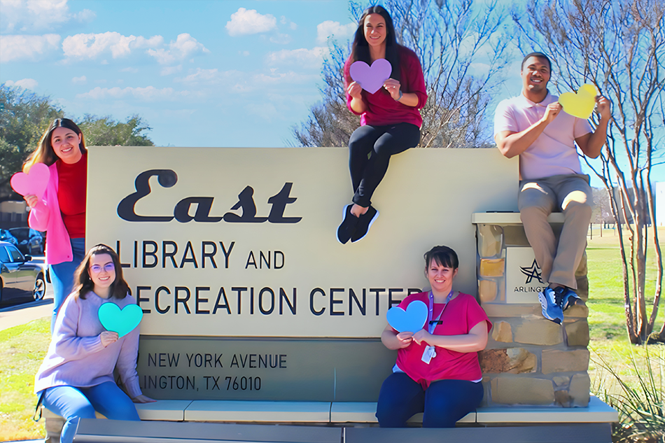 East Recreation staff posing by facility sign