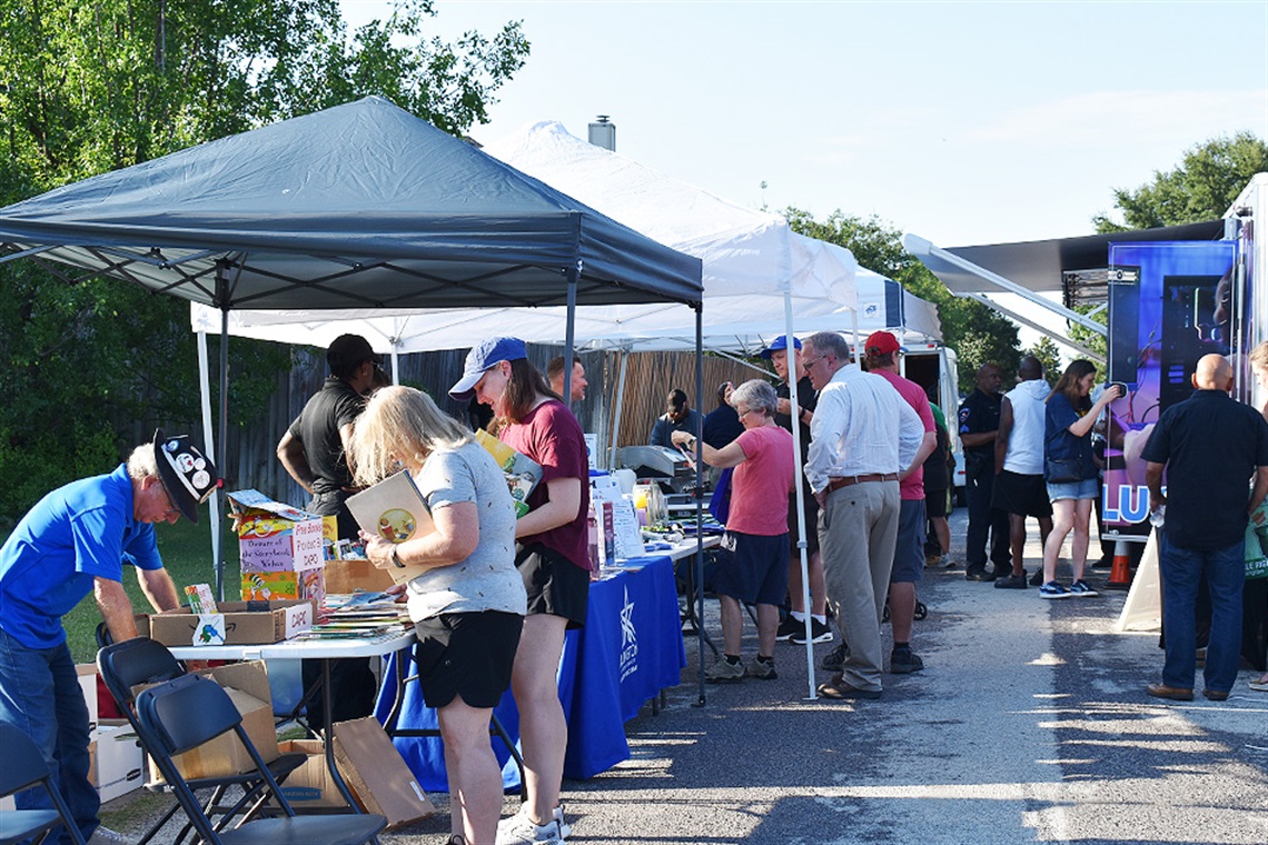 photo of a lively Neighborhood Enhancement Team (NET) Block Party in Arlington's Brighton Estates neighborhood. Many residents are shown engaging with city staff and community partners.