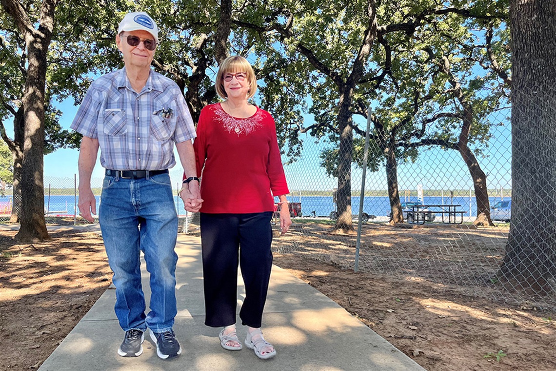Ken Cox and Doris Morgan hold hands while walking the trails at Richard Simpson Park on Sept. 26, 2024.