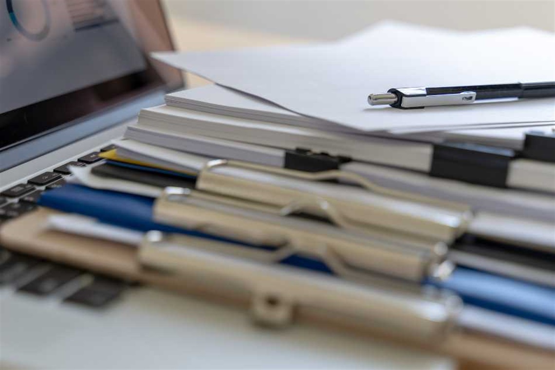 A laptop with papers bins