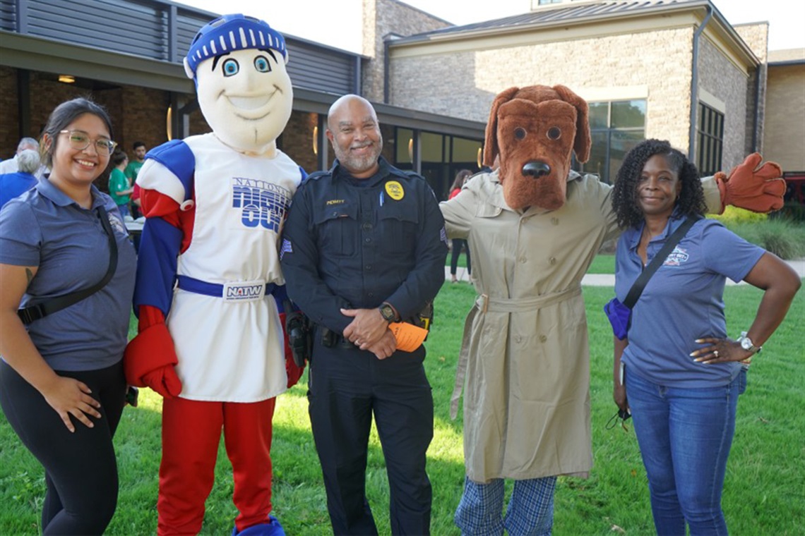 Members of the Arlington Police Department posing for a picture with National Night Out mascots.