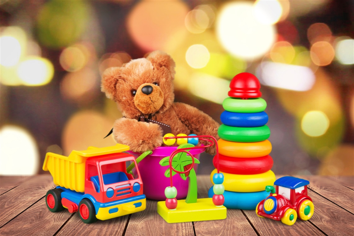 Teddy bear behind an assortment of children's toys.