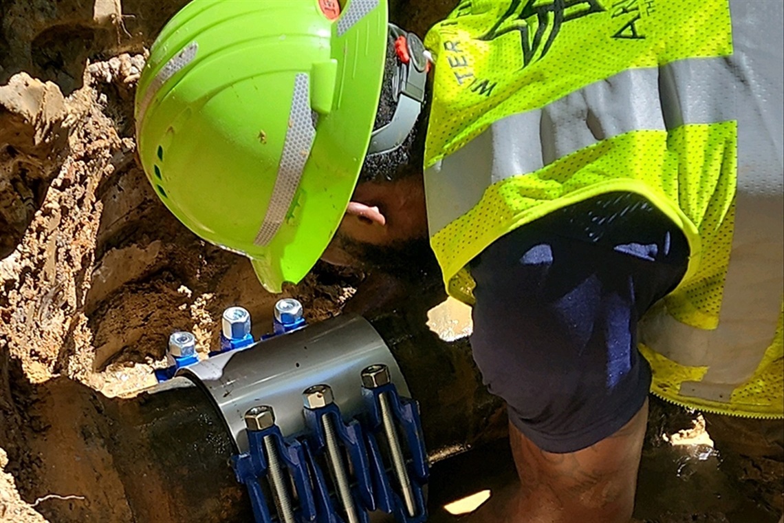 Arlington Water utilities employee repairing water main break