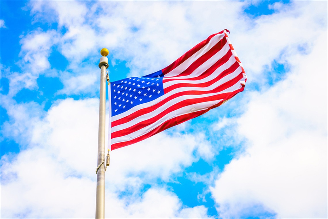 American flag flying over blue cloudy sky