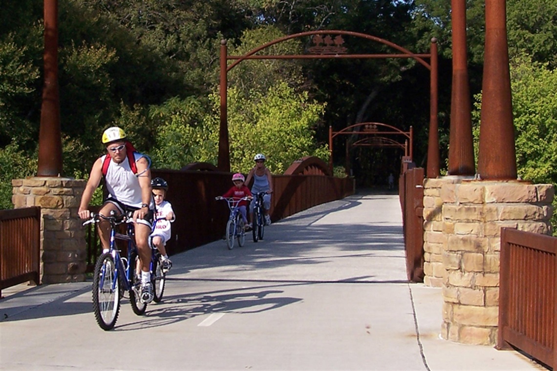 Man and kids on bicycle at River Legacy Bridge